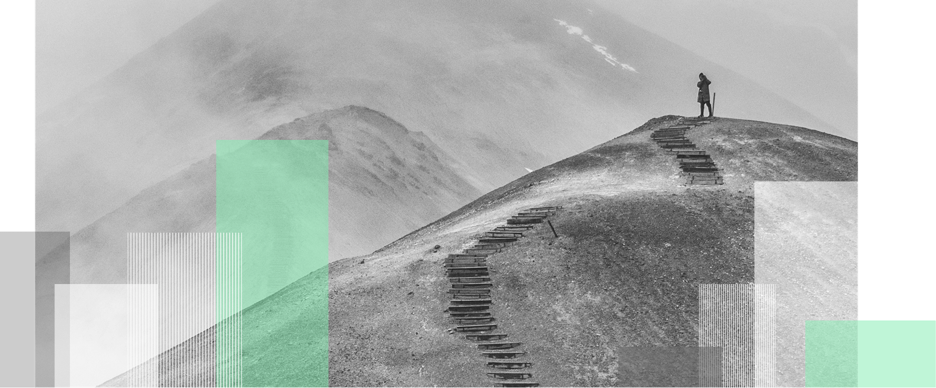 Persona en la cima de una colina pedregosa con escalones improvisados, sobre fondo de montañas brumosas y bloques geométricos verdes superpuestos